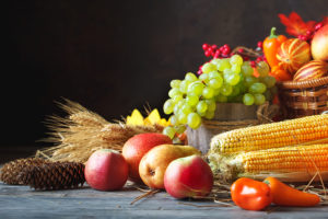 Happy Thanksgiving Day background, wooden table decorated with Pumpkins, Maize, fruits and autumn leaves. Harvest festival. Selective focus. Horizontal. Background with copy space.